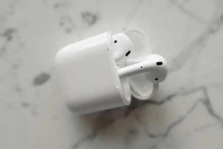 AirPods 4 à 69 dollars au Black Friday 2025 : l’ANC reste au vestiaire Modern wireless earphones in a sleek charging case on a marble surface.