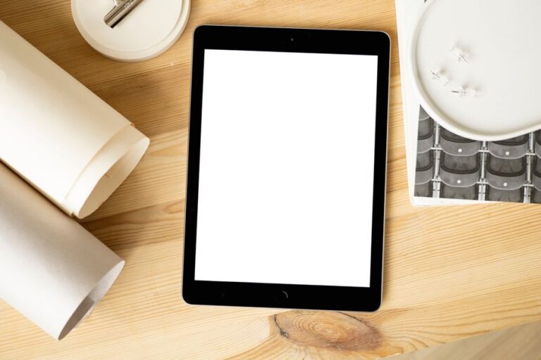 iPad A19, départs chez Apple et bague Pebble : la cadence en question Overhead view of a tablet mockup on a wooden desk with stationery, perfect for design presentations.