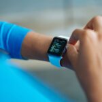 Apple Watch Series 11 à 299 dollars : le rabais ne desserre pas la serrure Person interacting with a smartwatch, showing a fitness application on the screen.