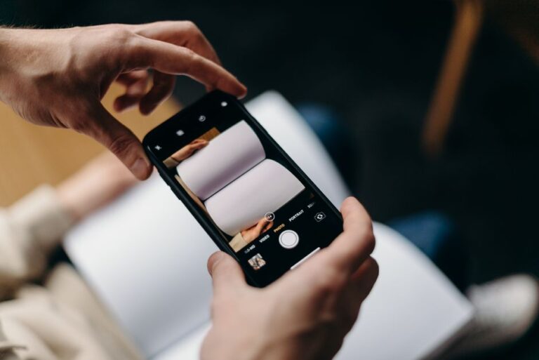 Apple Books 2025 : le bilan de lecture sort du bois Person using smartphone to photograph blank open book. Concept of mobile photography and creativity.