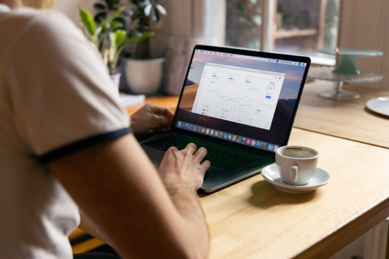 Microsoft Office 2024 à 99,97 $ : le piège du code Person working on a laptop with analytics in a cozy home office setting, coffee in hand.