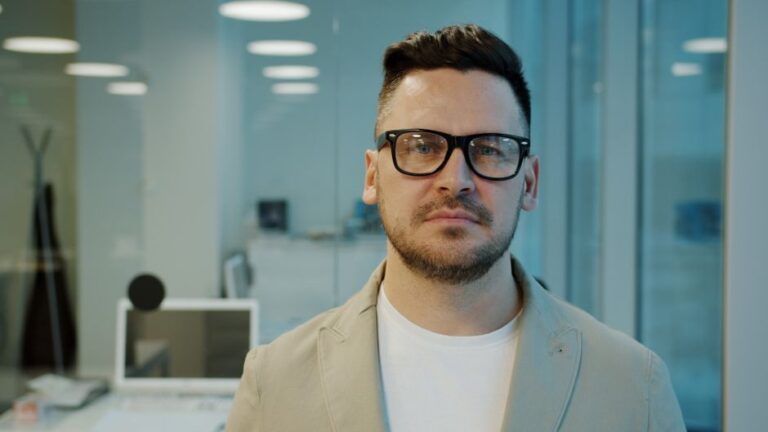 Google Glass à 1 500 dollars : le moment Steve Jobs a dérapé Portrait of a man with glasses in a modern office environment, looking serious.