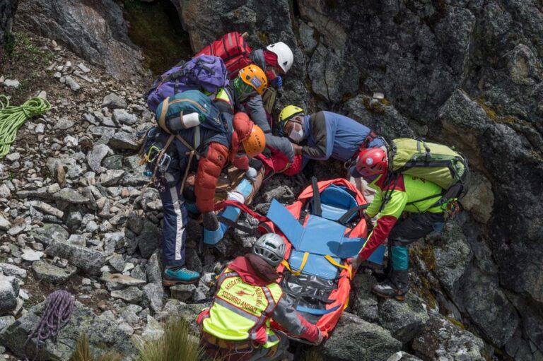Apple Watch Ultra 3 : chute aveugle, SOS au poignet Rescue team assisting injured hiker on rocky mountainside with stretcher.