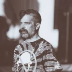 Alan Dye quitte Apple pour Meta le 31 décembre 2025: Liquid Glass change de pilote Sepia-toned portrait of a man with a beard wearing a tie-dye shirt outdoors during the day.