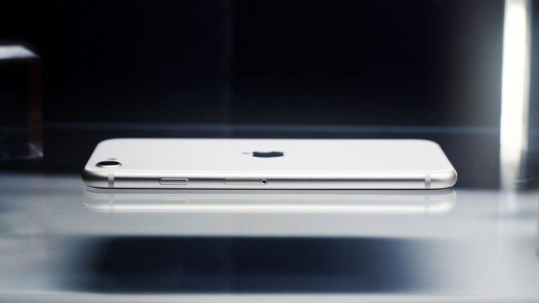 iPhone Air après quatre mois: 999 dollars pour gagner en finesse Side view of a sleek smartphone showcasing minimalist design on a reflective surface.
