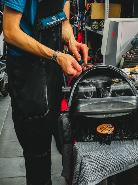 Skilled technician repairing an electric unicycle in a modern workshop setting.