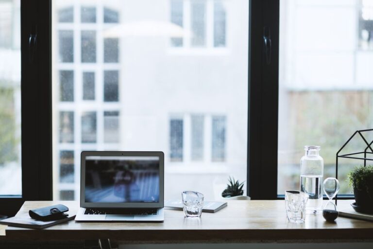 MacSync sur macOS : le faux installateur signé passe Gatekeeper Sleek office desk setup featuring a laptop, glass of water, and open window view.