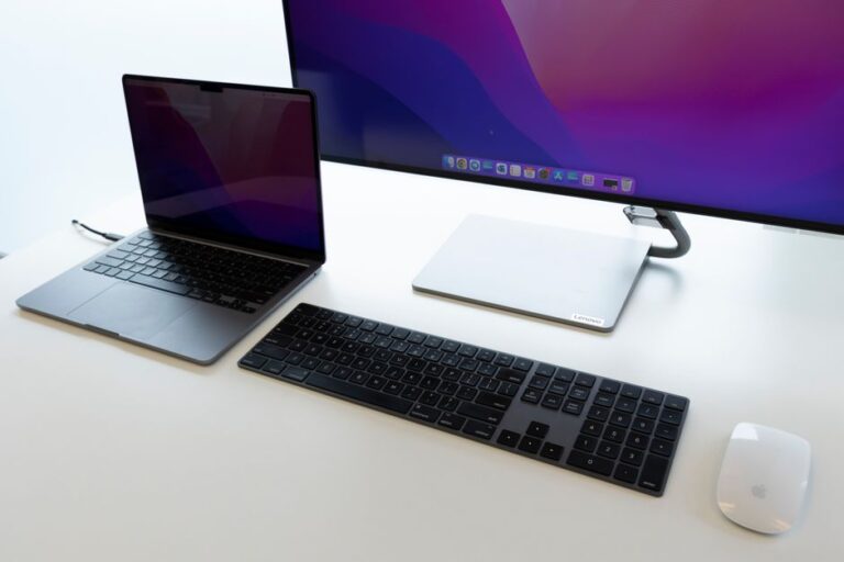 Samsung M80F 32 pouces à 399,99 $ : le Mac gagne de la place Sleek office desk setup with laptop, keyboard, and monitor for productive work environment.