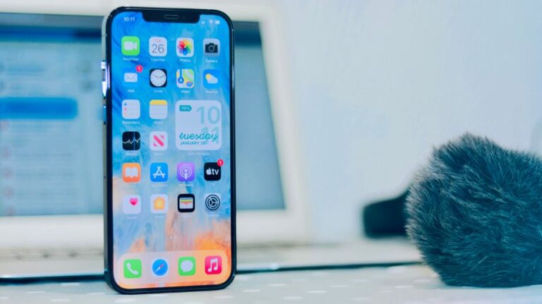 Écran connecté Apple au printemps 2026 : Matter 1.5 ouvre la porte, pas le jardin Smartphone displaying apps, notifications and time close-up indoors.