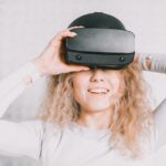 Apple Vision Pro M5 contre Steam Frame : 23 millions de pixels face au jeu VR Smiling woman wearing a VR headset and experiencing virtual reality excitement.