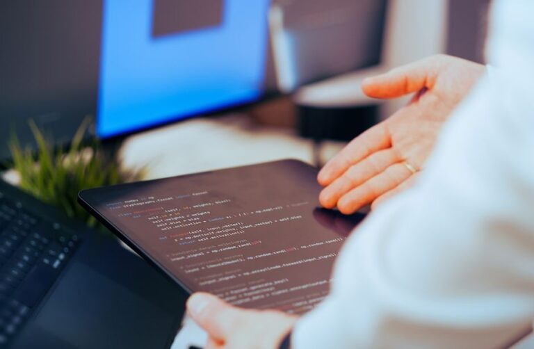 Frais App Store : 20 acteurs européens contestent Apple en décembre 2025 Software developer analyzing code on a tablet in a modern office workspace.