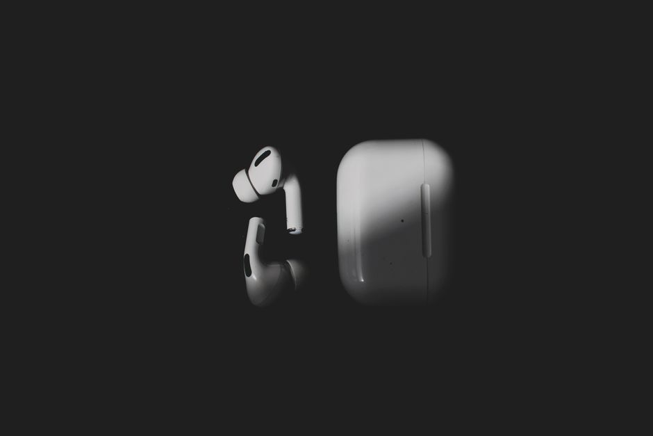 Stylish wireless earbuds and charging case on a sleek black background, featuring modern tech design.
