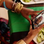 FaceTime bloqué en Russie le 10 octobre 2025 : le réseau coupe la ligne Woman using smartphone for a video call with a festive table setting. Celebrating cultural traditions digitally.
