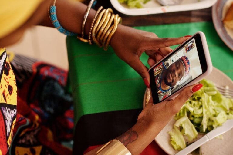 FaceTime bloqué en Russie le 10 octobre 2025 : le réseau coupe la ligne Woman using smartphone for a video call with a festive table setting. Celebrating cultural traditions digitally.