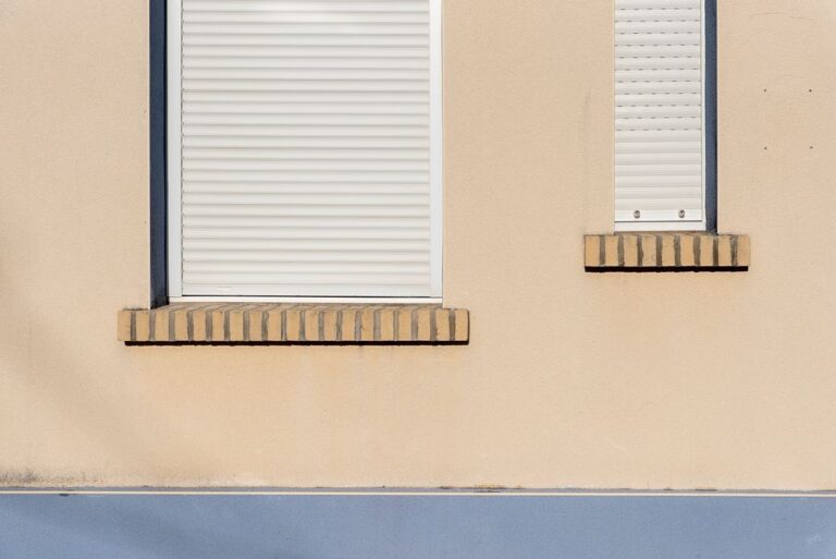 GE Smart Shades à 299,99 dollars : Apple Home baisse les stores au CES 2026 A beige building facade with closed white roller blinds and minimal architectural design.