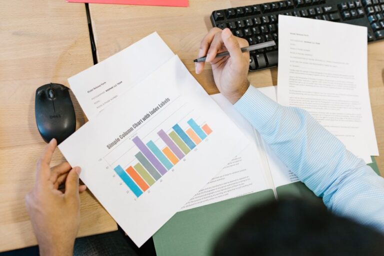 iPhone 17 : 136,7 milliards de dollars attendus le 29 janvier, l’IA au banc d’essai A business analyst reviews a colorful bar chart and documents at a desk, indicating data analysis.