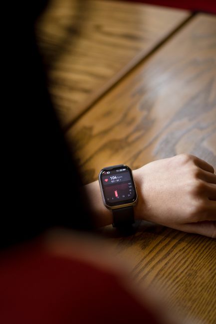 A close-up shot of a smartwatch on a wrist showing a heart rate of 104 bpm.