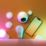 Govee dévoile trois éclairages Matter pour Apple Home au CES 2026, sans prix A collection of smart home devices including light bulbs and a smartphone, showcasing modern technology.
