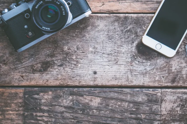 iPhone 18 Pro en 2026 : la Dynamic Island pourrait déménager, joli bazar en vue A flat lay of a vintage camera and smartphone on a rustic wooden table, ideal for tech and photography themes.