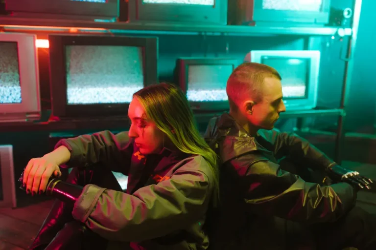 Criminal Record saison 2 arrive le 22 avril 2026, Londres voit rouge A futuristic scene capturing two individuals in a cyberpunk setting surrounded by televisions.