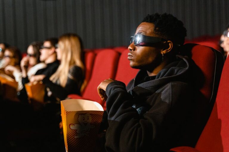 Apple Vision Pro: le premier match NBA immersif est gratuit, mais pas partout A group of adults in a cinema wearing 3D glasses watching a movie and eating popcorn.