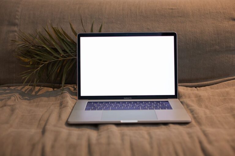 Creator Studio sur Mac : Pages 15.1 ne s’installe pas d’un clic A laptop with a blank screen sitting on a comfortable sofa, ideal for design and technology themes.