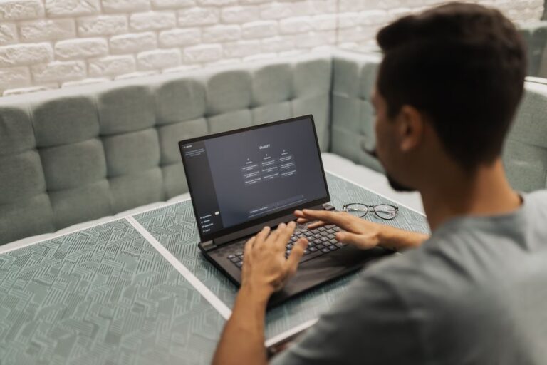 Siri avec Gemini en 2026 : Apple prête le moteur, garde le volant A man working on a laptop in a cozy, modern office space with a focus on technology.