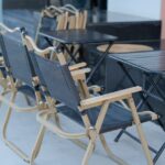 A neat arrangement of foldable chairs and tables outside, perfect for outdoor gatherings.