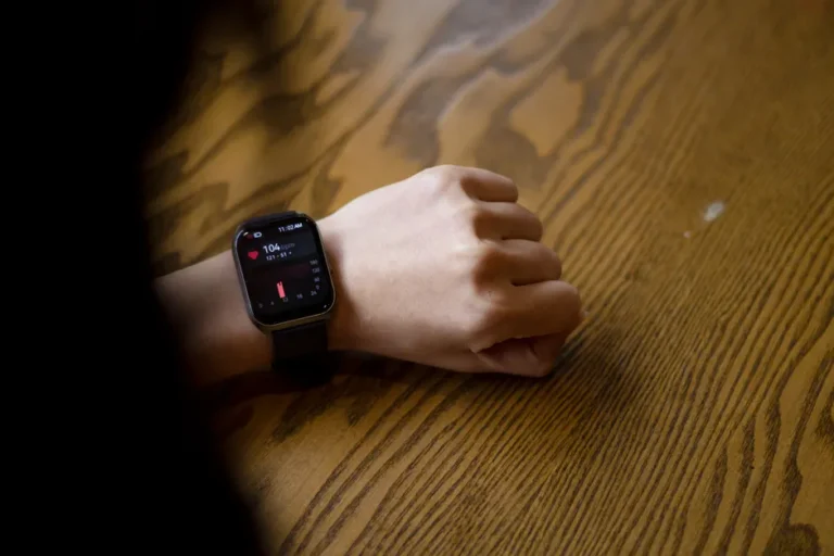 Apple Watch contre AliveCor : la voie antitrust se ferme le 8 janvier 2026 A person checks heart rate on smartwatch showing 104 bpm on wooden table.