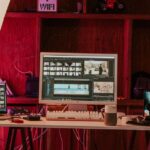 Apple Creator Studio à 12,99 € : le studio ne fait pas tout le montage A professional video editing workspace featuring monitors, keyboard, and microphones in a studio setting.