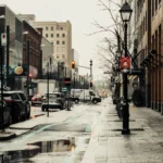 A rainy day scene on Sainte-Catherine Street in Montreal capturing urban life and architecture.