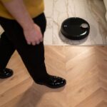 Roborock au CES 2026 : 36 000 Pa et quatre machines A robotic vacuum cleaner operating on a wooden floor, viewed in high angle indoor setting.