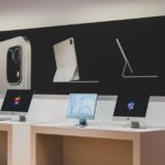 A sleek computer store featuring modern desktop displays and technology advertisements.