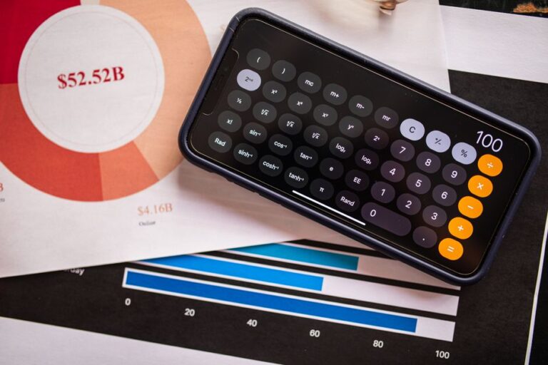 iPhone 16 : Apple place 7 modèles dans le top 10 de 2025, et ça pique A smartphone displaying a calculator app on financial charts, showcasing revenue analysis.