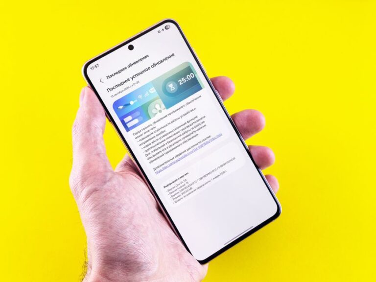 iOS 26.3 bêta 3 arrive le 26 janvier : Apple serre les boulons A smartphone displaying an update notification held by a person's hand against a bright yellow background.