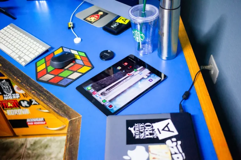 Apple Creator Studio arrive le 28 janvier 2026 à 12,99 $ : le piège du bundle A vibrant workspace featuring an iPad, keyboard, mouse and a tumbler on a blue desk.