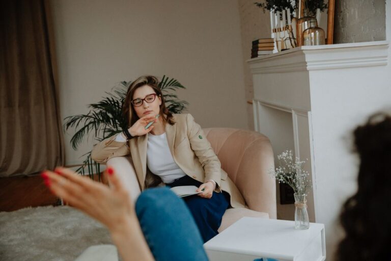Shrinking saison 4 confirmée par Apple TV le 27 janvier 2026 : le divan rempile A woman counselor attentively listens during a therapy session in a cozy office environment.