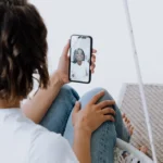 FaceTime Eye Contact : le brevet européen qui vise Apple A young woman engages in a cheerful video call with a friend using a smartphone.