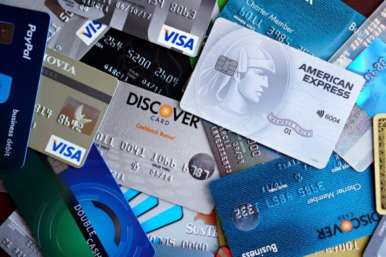 Apple Card chez Chase en 2026 : le jardin clos change de banquier Close-up image of various credit cards including Visa, Mastercard, and American Express.