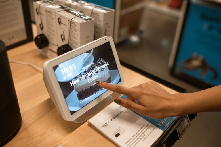 Apple Home Hub : la base pivotante reste une rumeur Close-up of a hand using a smart display showing a recipe for brownie cakes in a store setting.