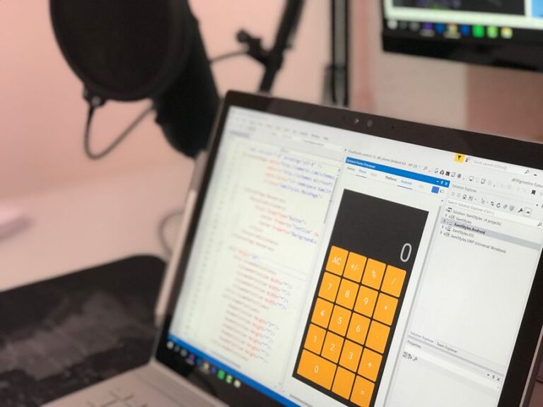 Launchpad supprimé de macOS Tahoe 26 : le plan B Close-up of a laptop displaying code and a calculator app in a modern workspace.