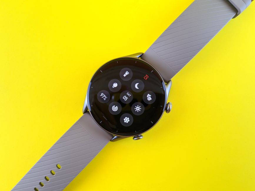 Close-up of a modern smartwatch display on a vibrant yellow background.