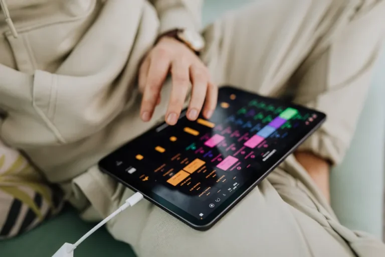 Gemini chez Apple, Pixelmator Pro sur iPad : le jardin s’agrandit Close-up of a person using a touchscreen tablet with a colorful interface indoors.