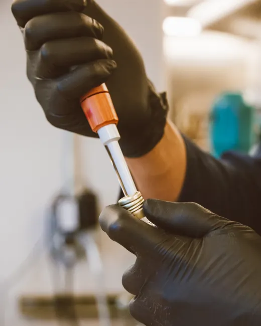 Close-up of a scientist using a pipette in a laboratory setting with gloves on hands.