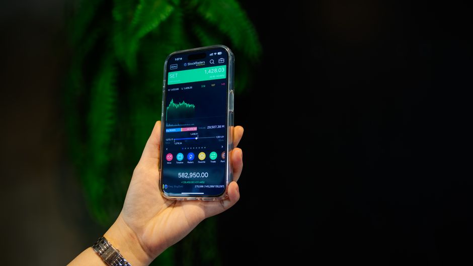 Close-up of a smartphone displaying a stock trading app with market data on-screen.