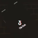 TikTok US change de pilote en 2026 : l'algorithme attendra Close-up of a smartphone displaying the TikTok app logo against a dark keyboard background.