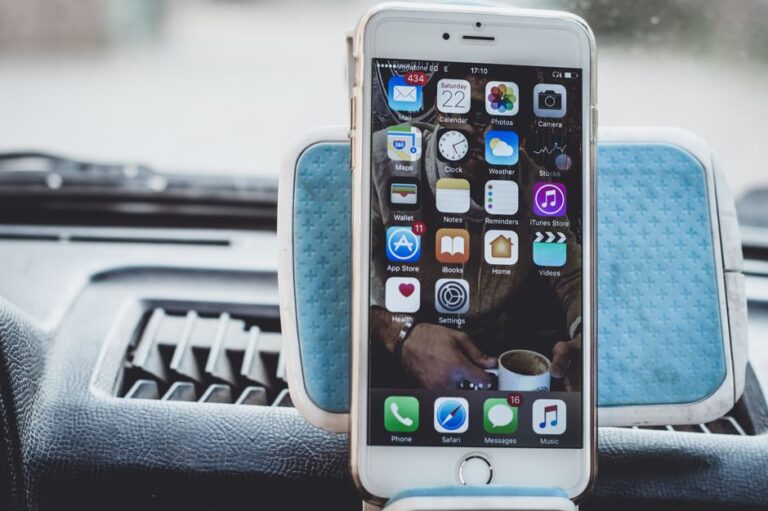 iPhone 18 : Dynamic Island réduite en 2026, bordures inchangées Close-up of a smartphone mounted on a car dashboard showing home screen with apps.