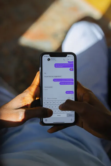Close-up of person texting on smartphone with focus on screen chats.