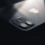 Close-up shot of a smartphone camera lens reflecting light, highlighting modern technology.