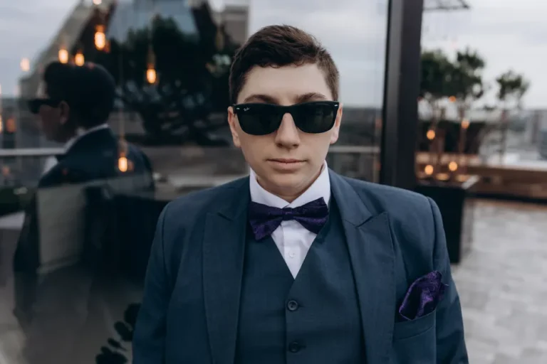 Steve Jobs : 12 nœuds papillon, un bureau d’enfance et un câble d’Apple-1 aux enchères en 2026 Confident man in sunglasses and bowtie standing on a city rooftop, showcasing elegance and sophistication.